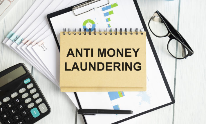 Paper with text AML Anti Money Laundering on a table